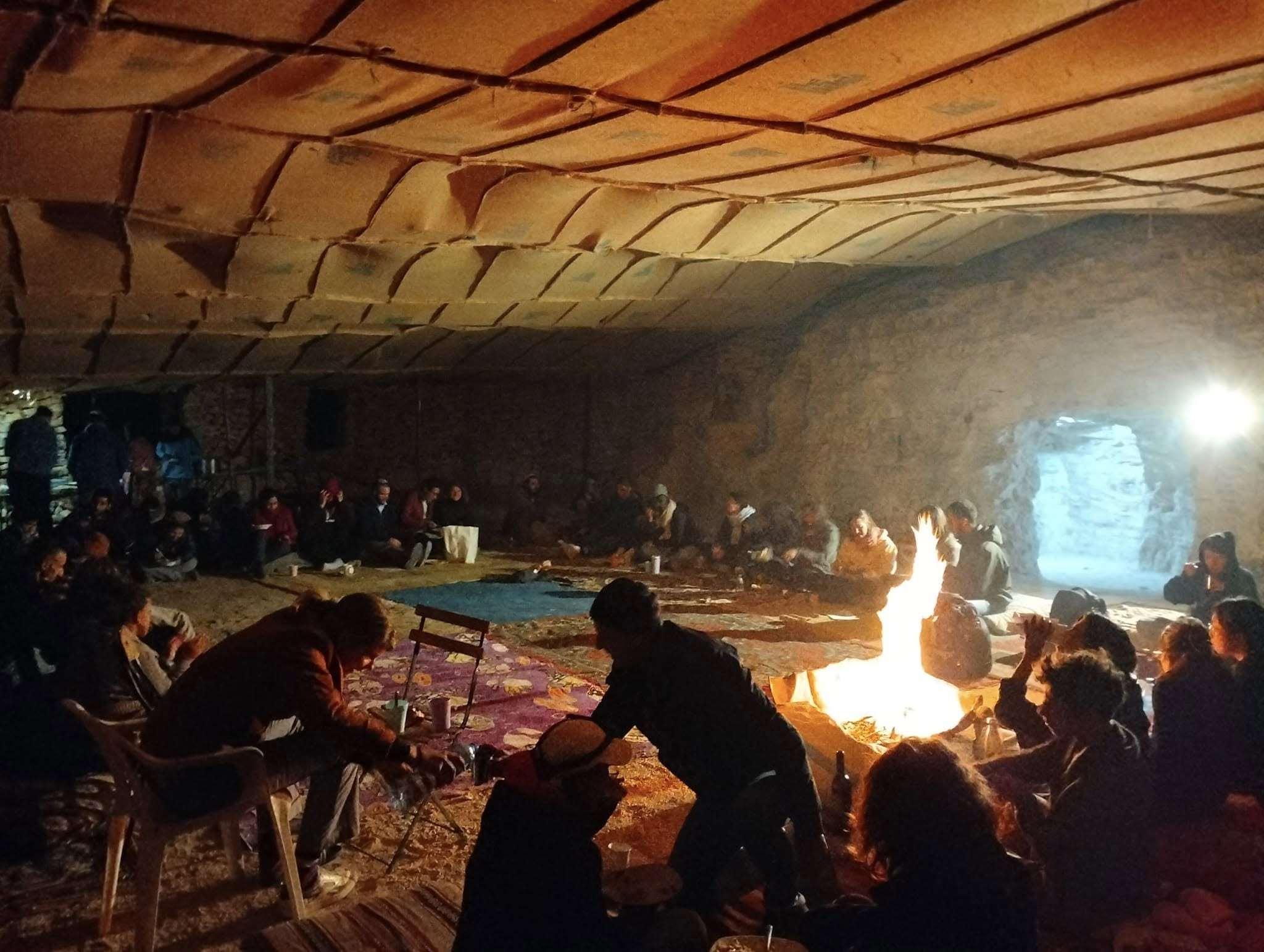 An evening gathering around a fire inside the camp