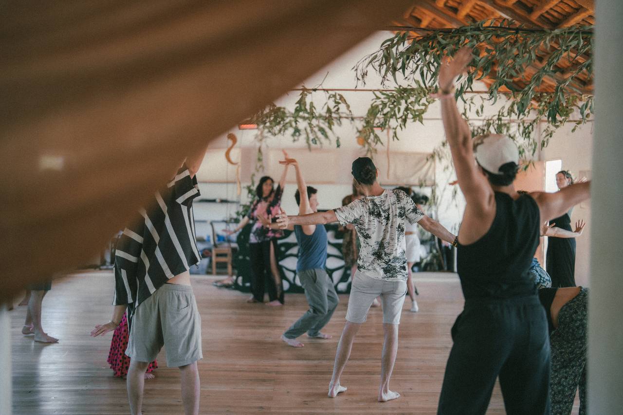 Participants moving together inside a light-filled workshop space