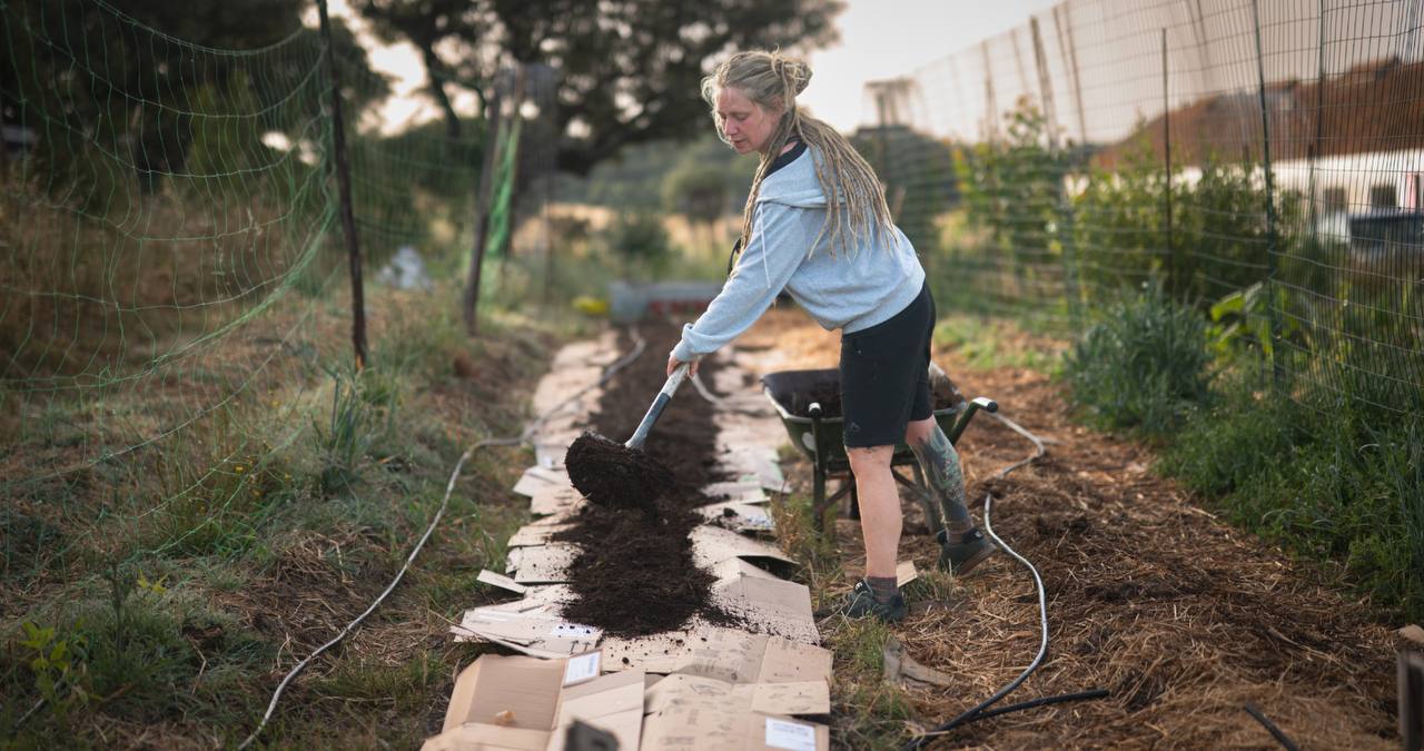 A participant adding compost to a garden bed