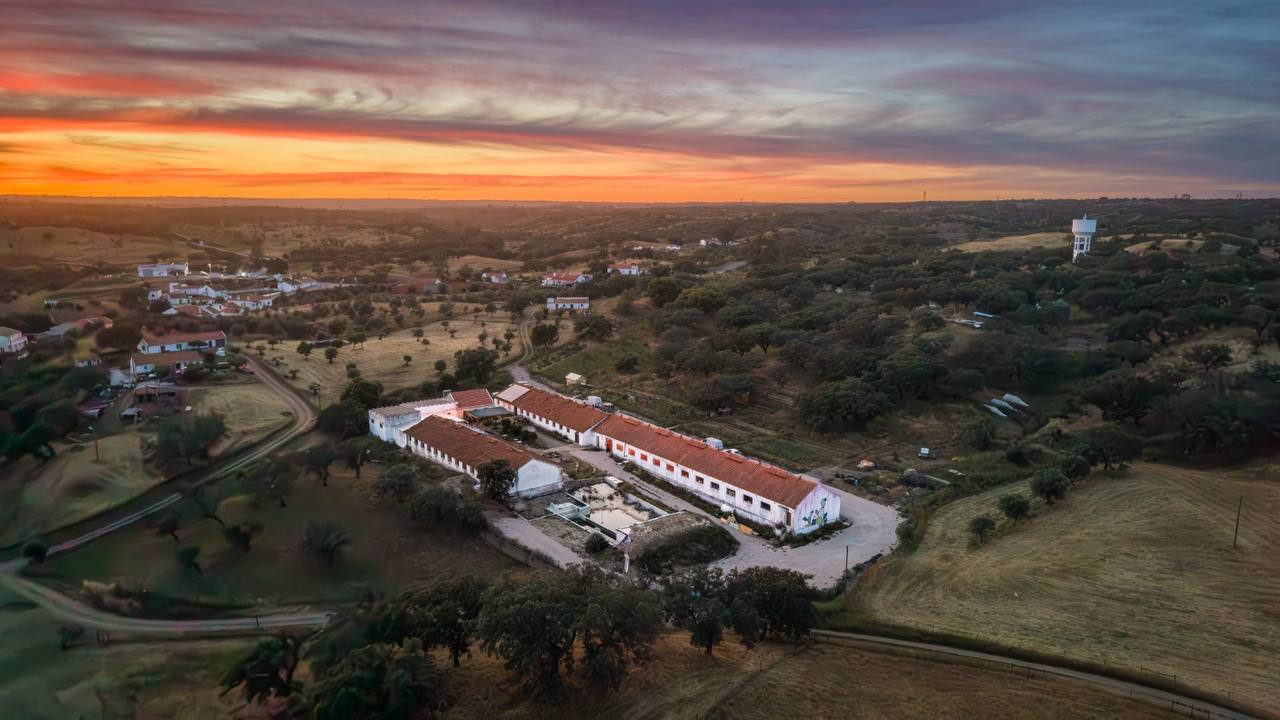 Traditional Dream Factory among cork-oak fields beneath a vivid sunset